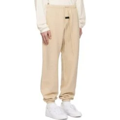 Fear Of God Essentials Gold Heather Sweatpants (FW23) 8 Fear Of God Essentials Gold Heather Sweatpants (FW23) -Creps Lockers fear of god essentials gold heather sweatpants fw23 model side